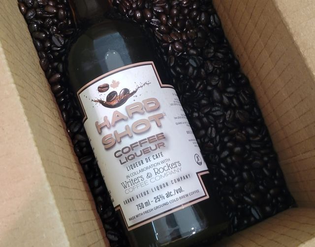 Delicious coffee liqueur nesting in a box with coffee beans.